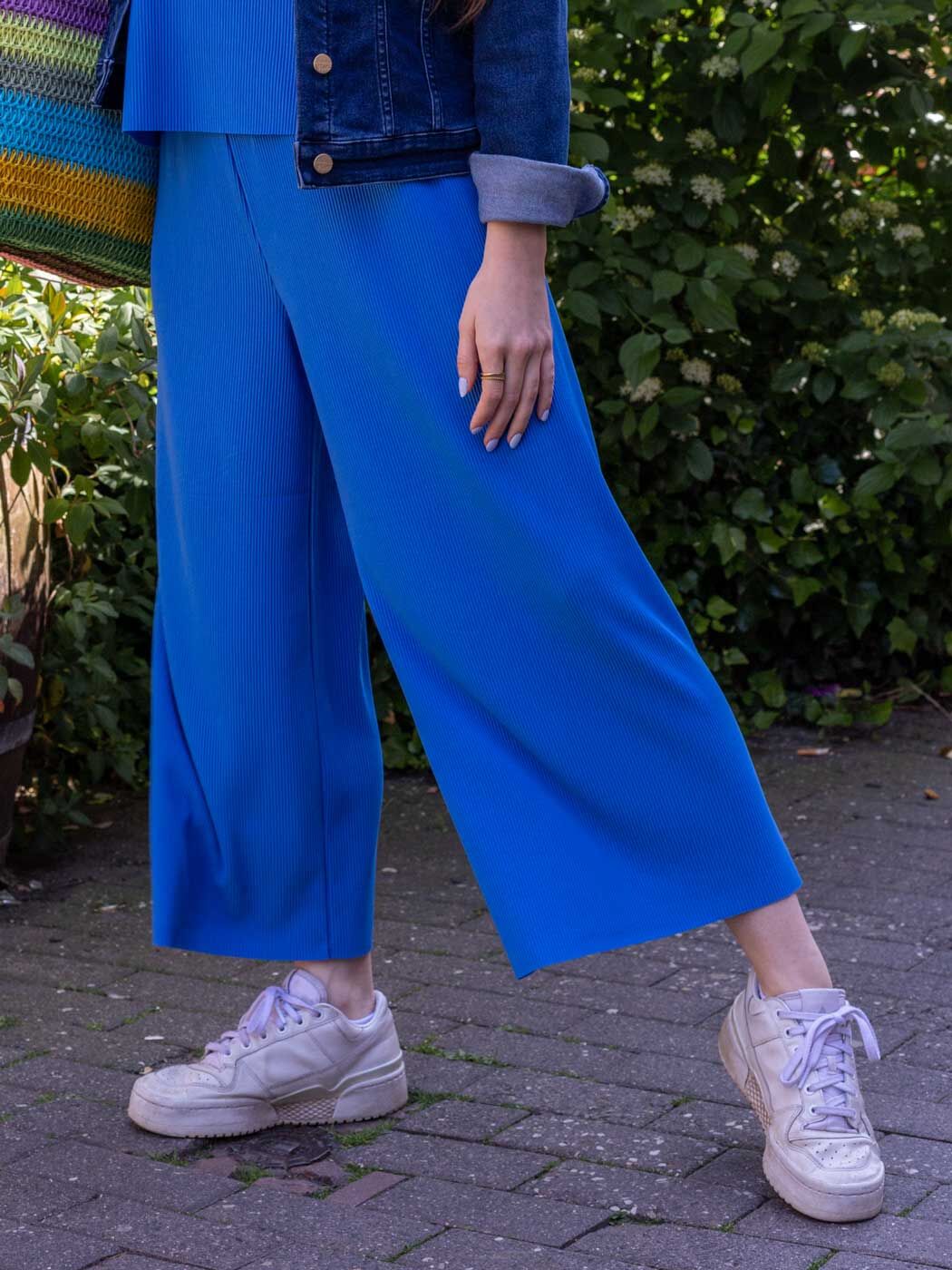 Frau in einer blauen, weit geschnittenen Culotte