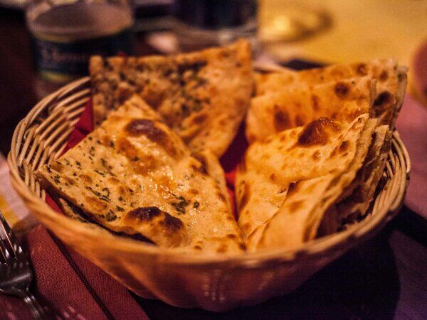 Ein Korb mit indischem Brot steht auf einem Tisch.