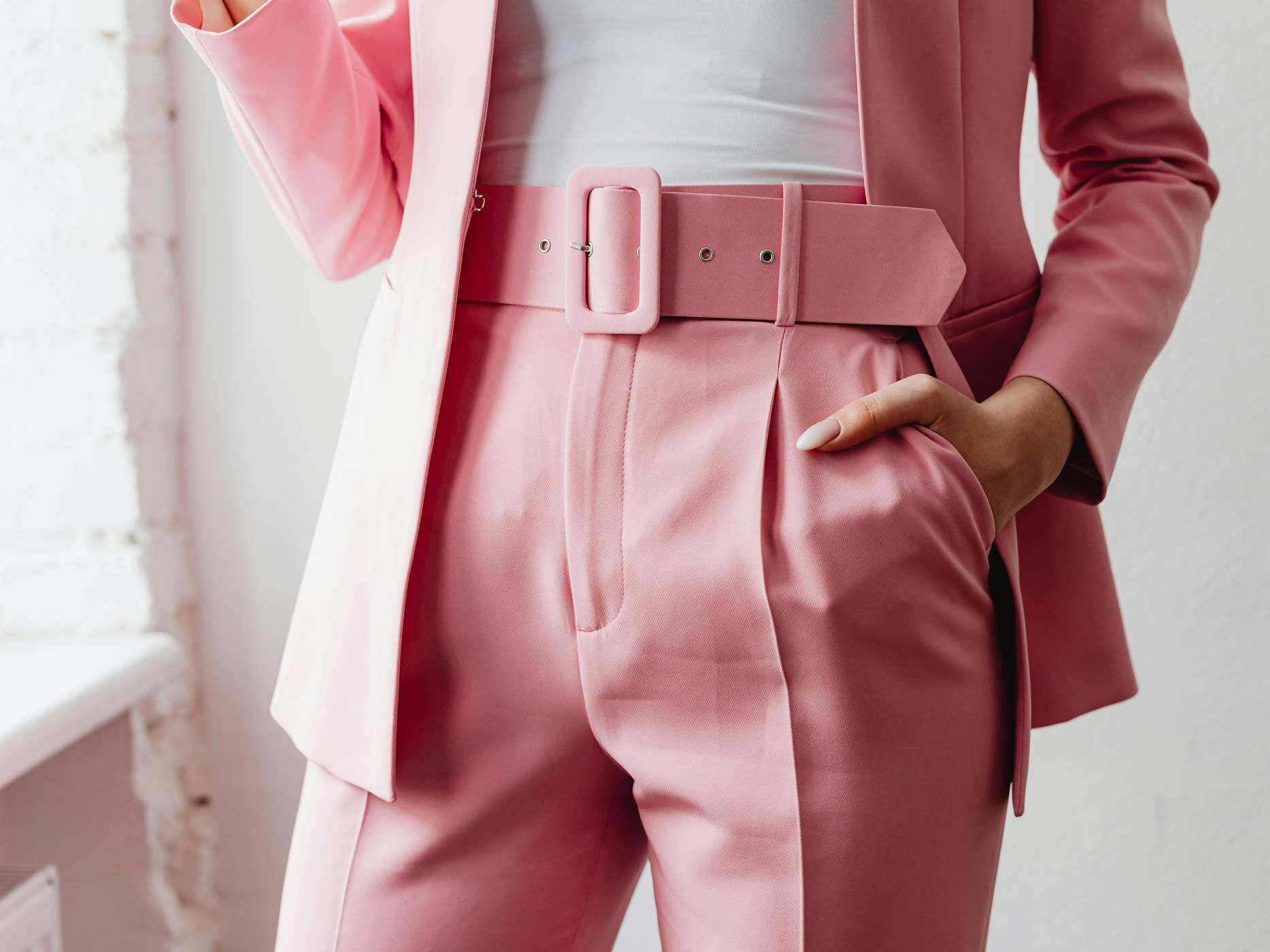 Nahaufnahme einer pinken Anzughose, einem weißen Top und einem gleichfarbigen pinken Blazer.