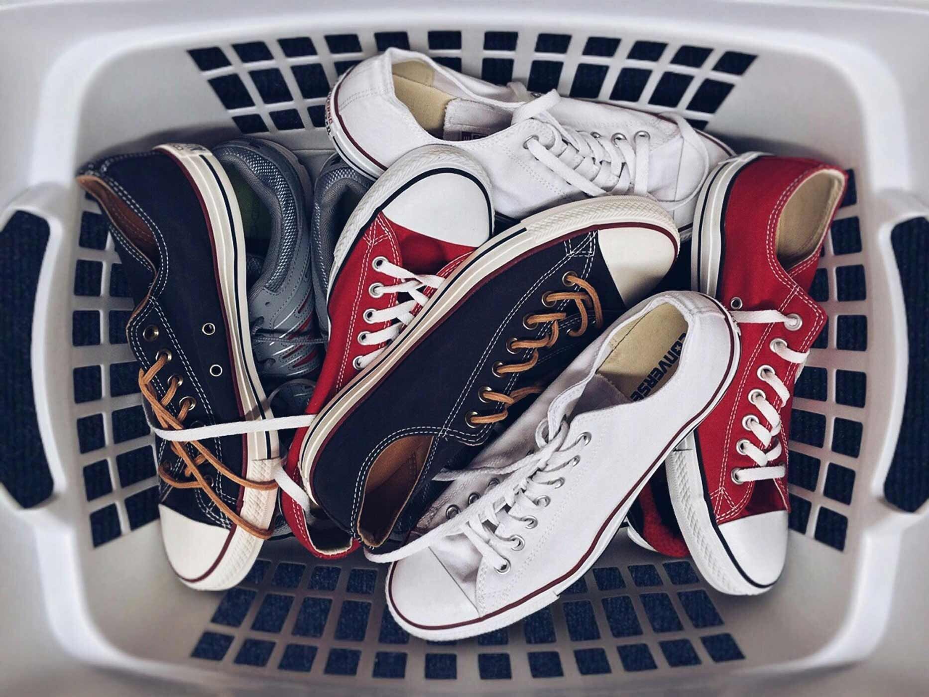 In einem Wäschekorb liegen viele Schuhpaare von Chucks durcheinander.