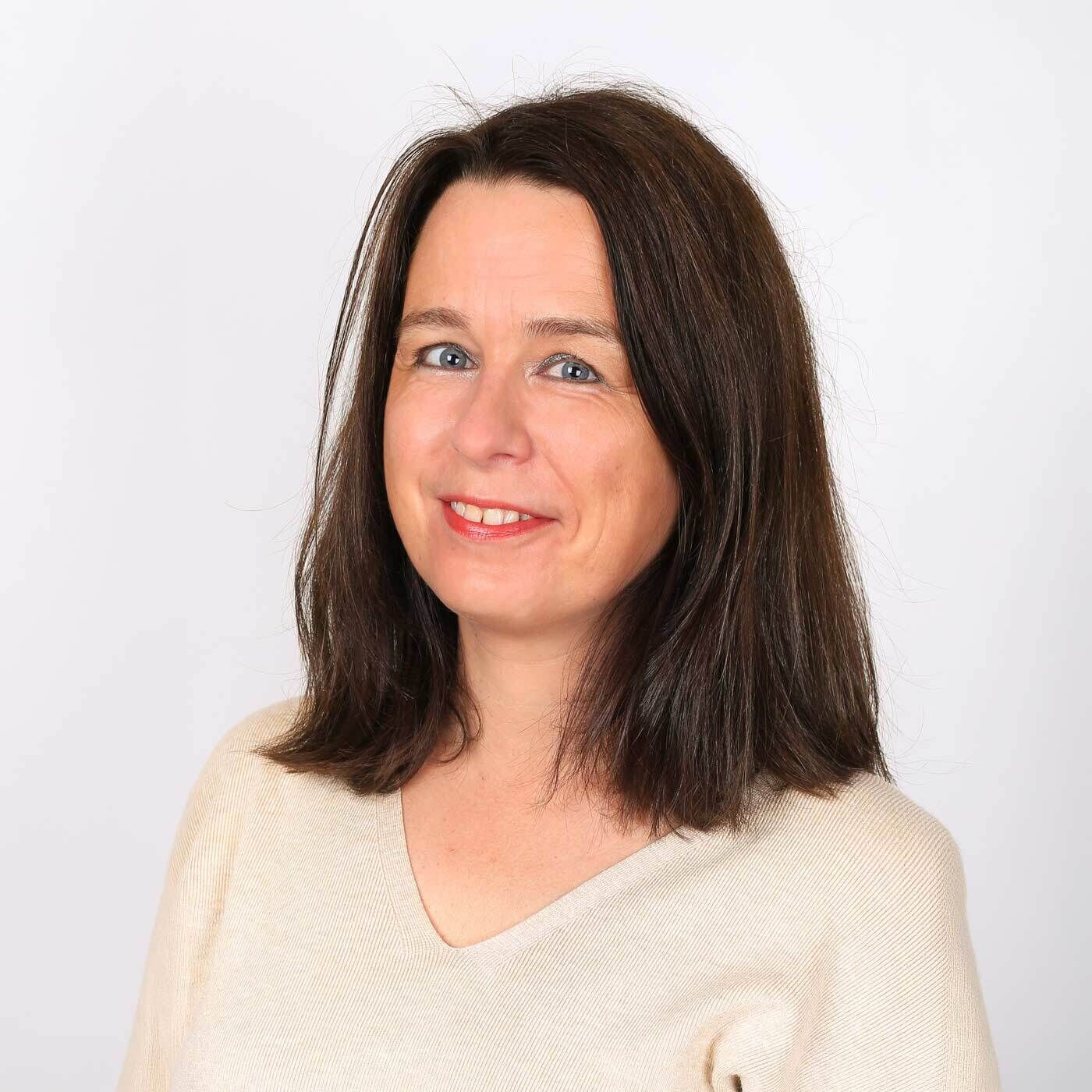 Portraitfoto von MAC-Expertin Verena. Sie hat braune mittellange Haare, blaue Augen und l&auml;chelt in die Kamera. Sie tr&auml;gt einen beigen Pullover.