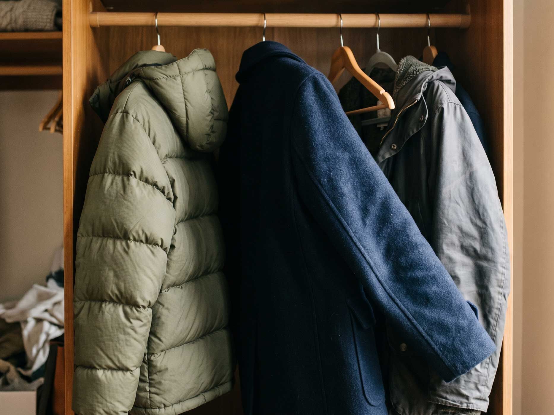 Mehrere Winterjacken h&auml;ngen ordentlich und luftig im Kleiderschrank, damit Materialien und Formen erhalten bleiben.