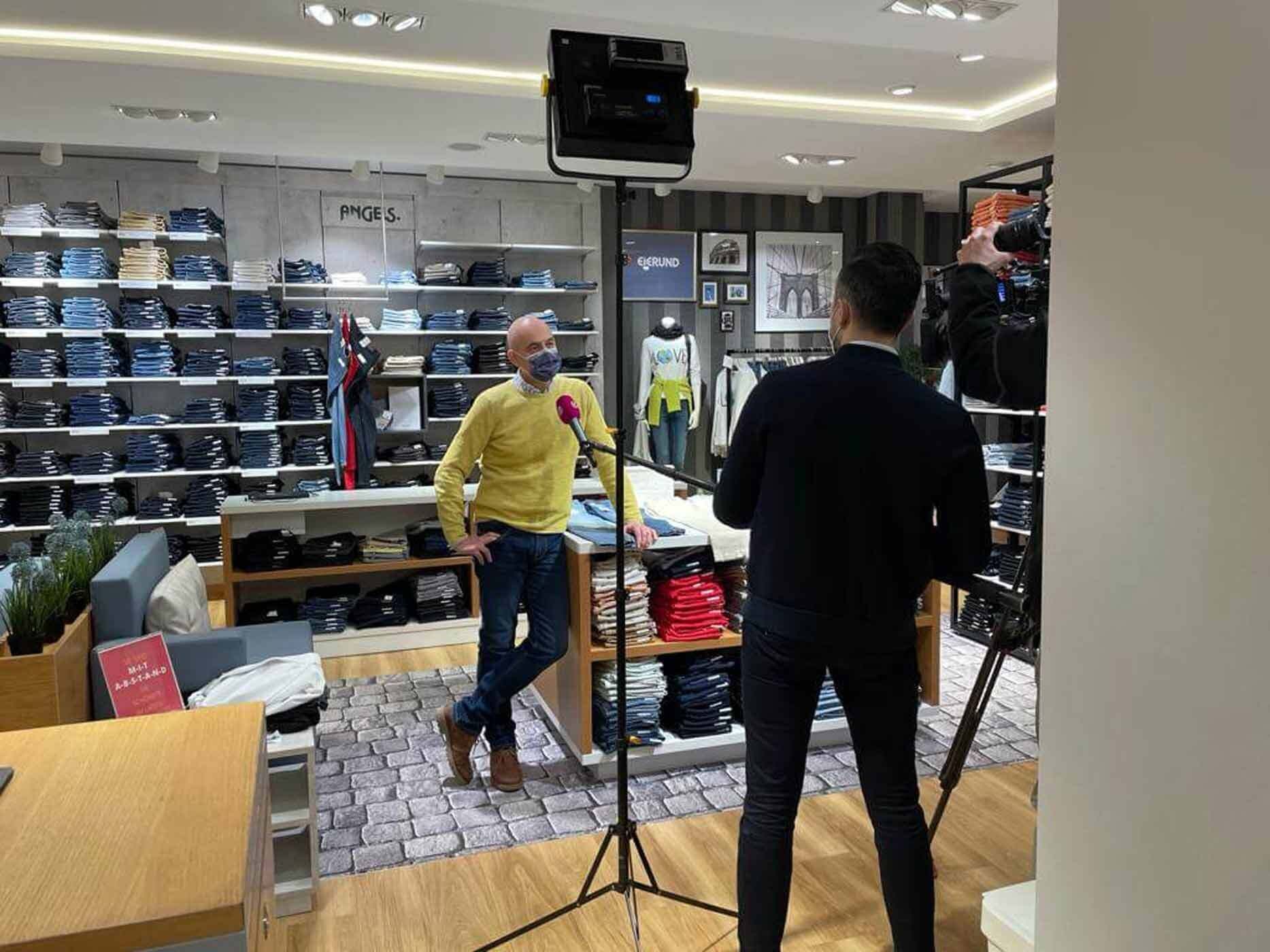 Tobias Eierund steht vor einem Mikrofon und Kameras und gibt ein Interview f&uuml;r Sat1.