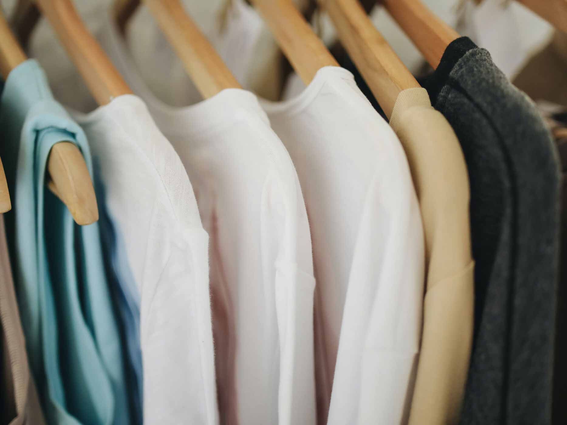 Mehrere Pullover hängen an einer Kleiderstange