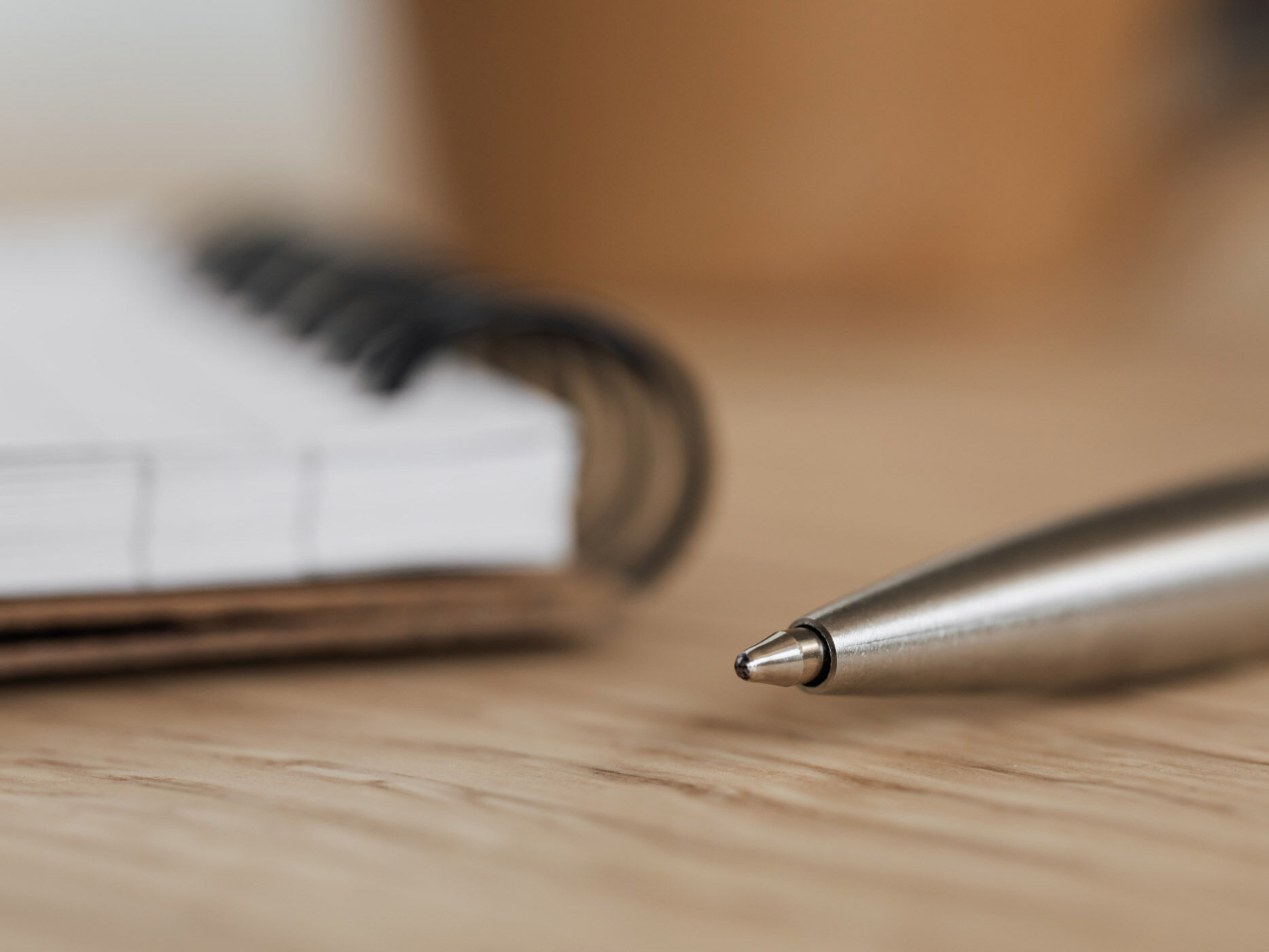 Kugelschreiber mit ausgefahrener Mine vor einem Notizblock