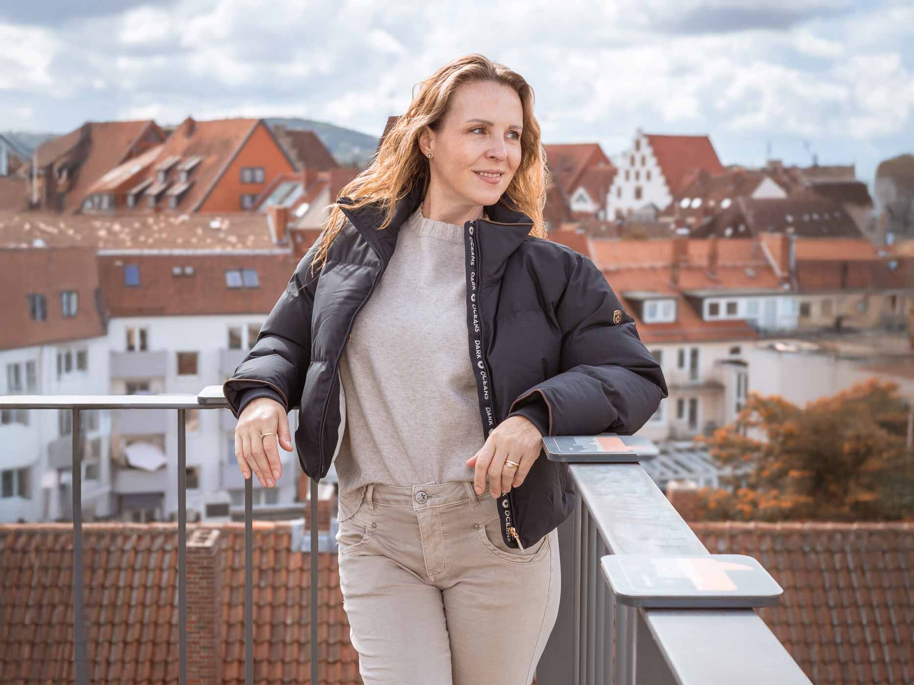 Eine Frau steht auf einer Aussichtsplattform und trägt eine kurze, schwarze Wellensteyn Jacke.