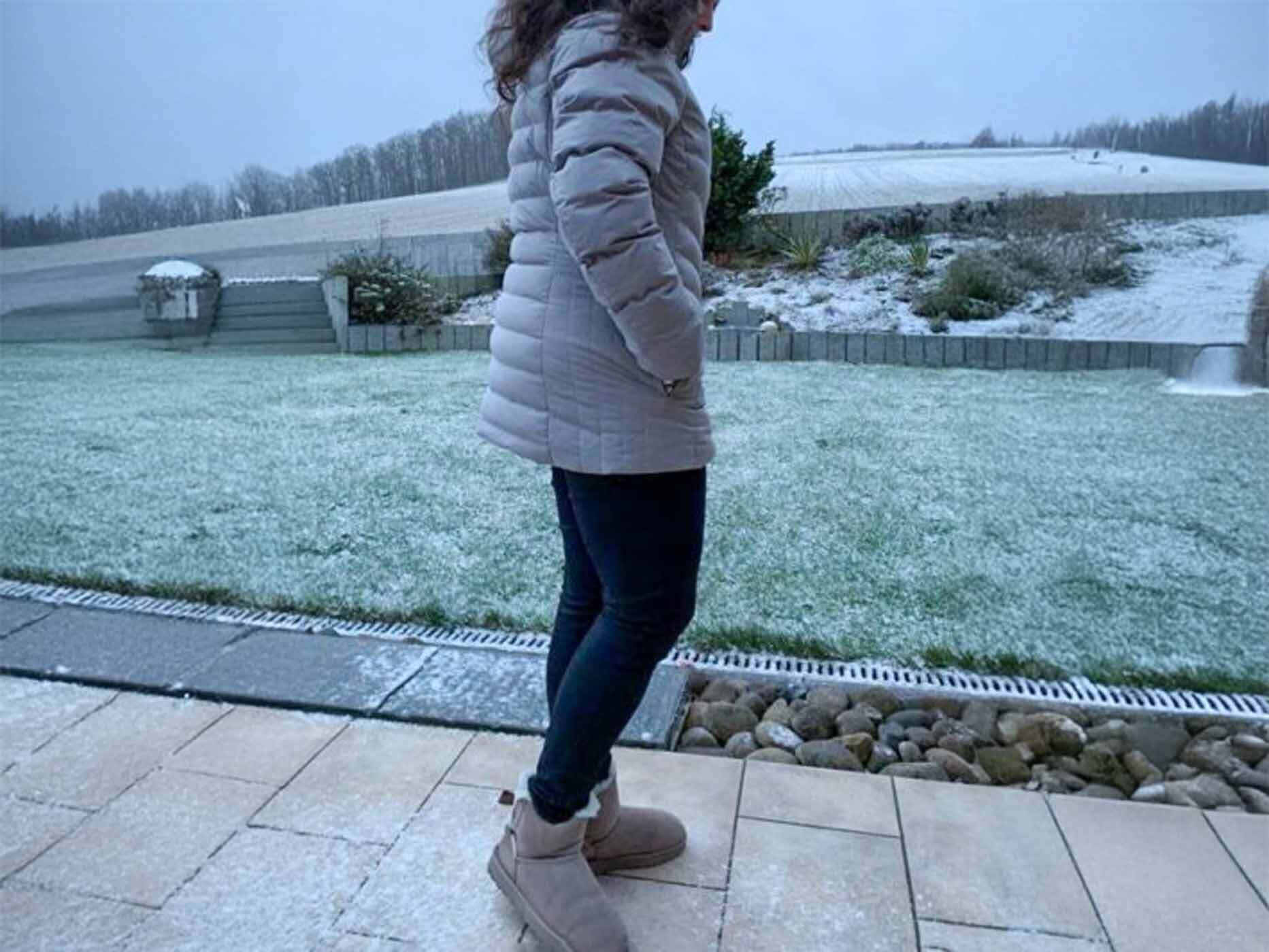Junge Frau tr&auml;gt eine hellgraue Wellensteyn Winterjacke, Seitansicht.