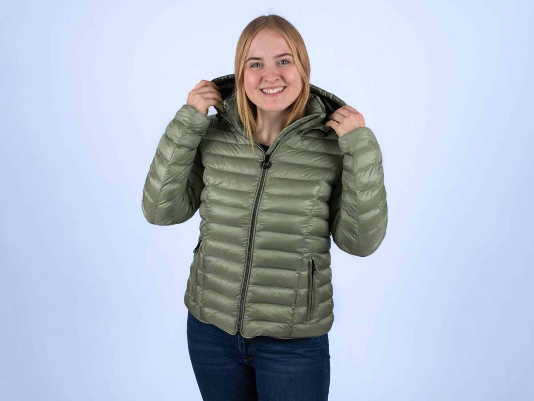 Junge Frau trägt die Wellensteyn Italy Hood in Salbeigrün geschlossen und hält die Kapuze.
