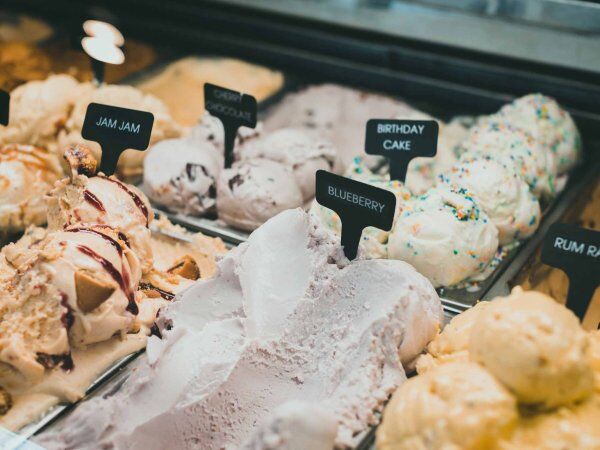 Verschiedene Eissorten stehen in Containern nebeneinander.