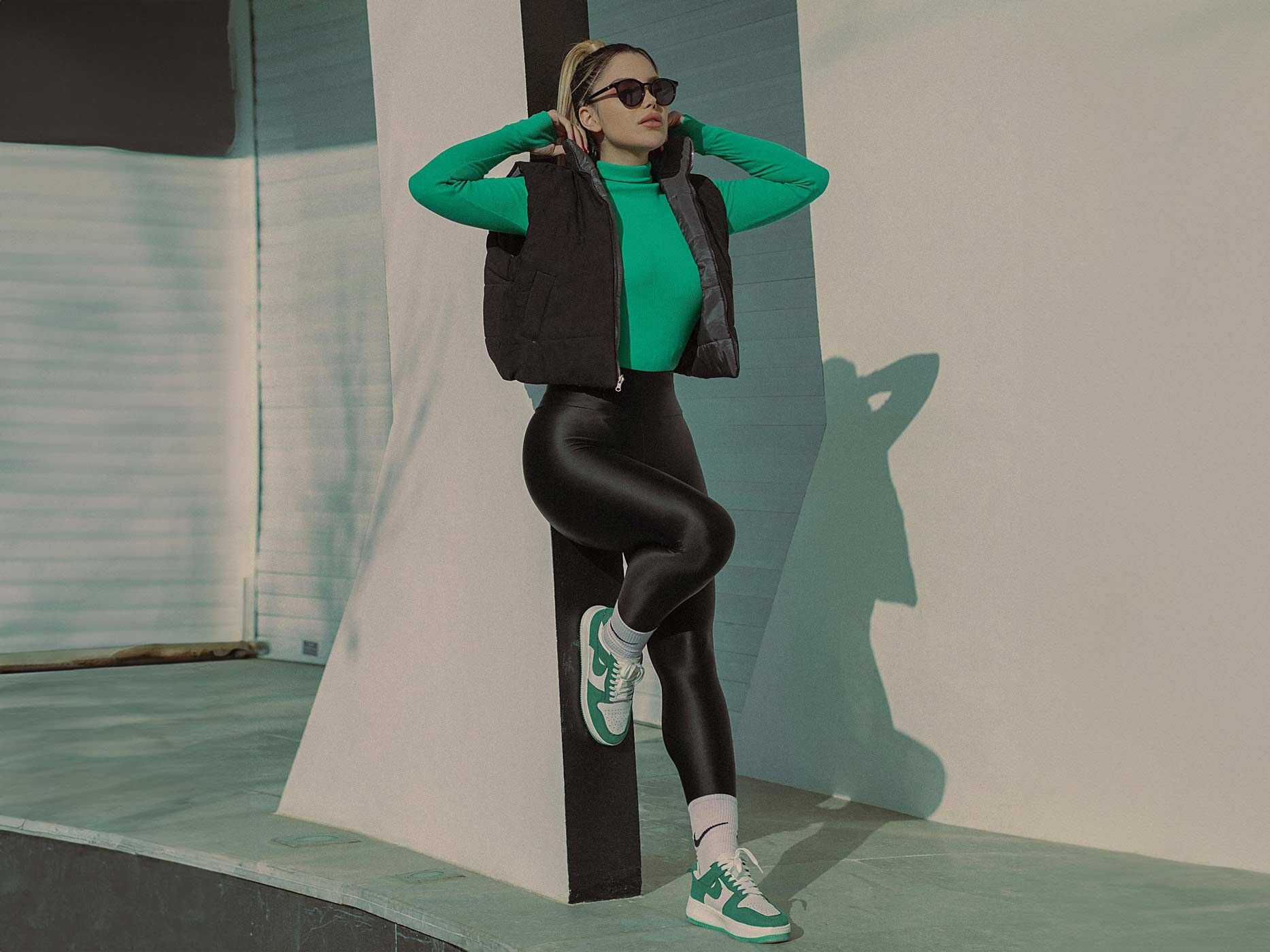 Frau trägt Sportoutfit mit schwarzer Leggings