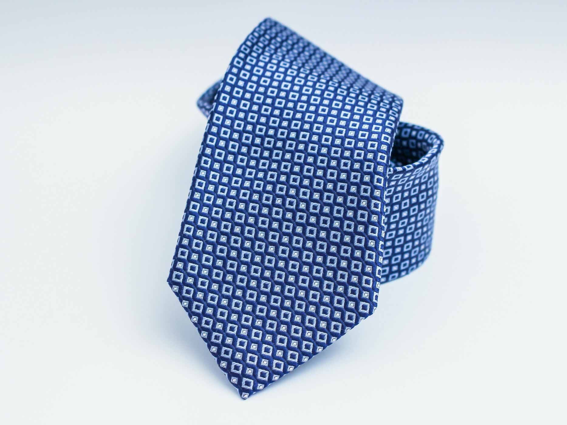 Eine blau-weiß gepunktete Krawatte liegt aufgerollt auf einem Tisch