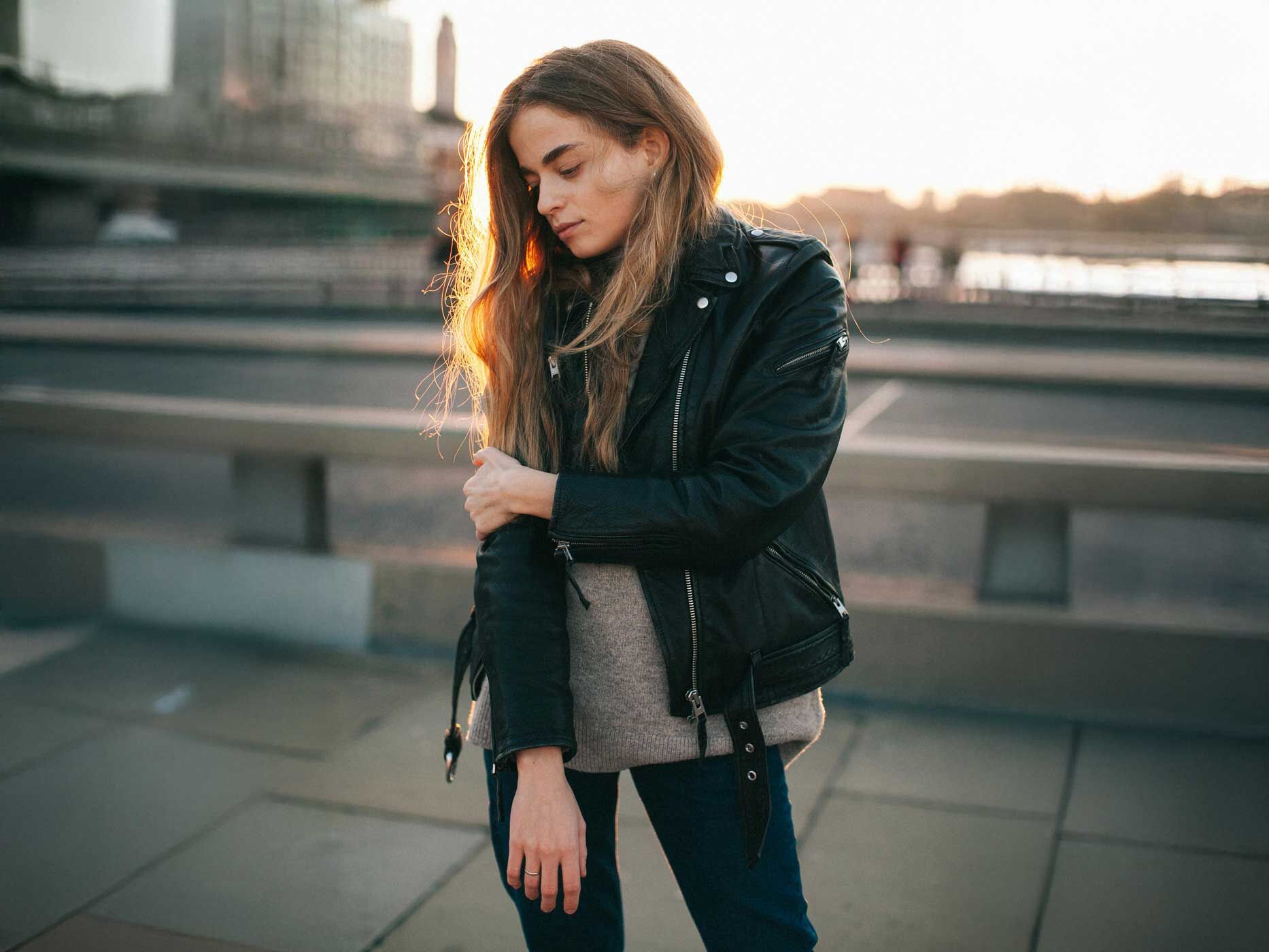 Eine Frau trägt eine Lederjacke mit vielen Reißverschlüssen.