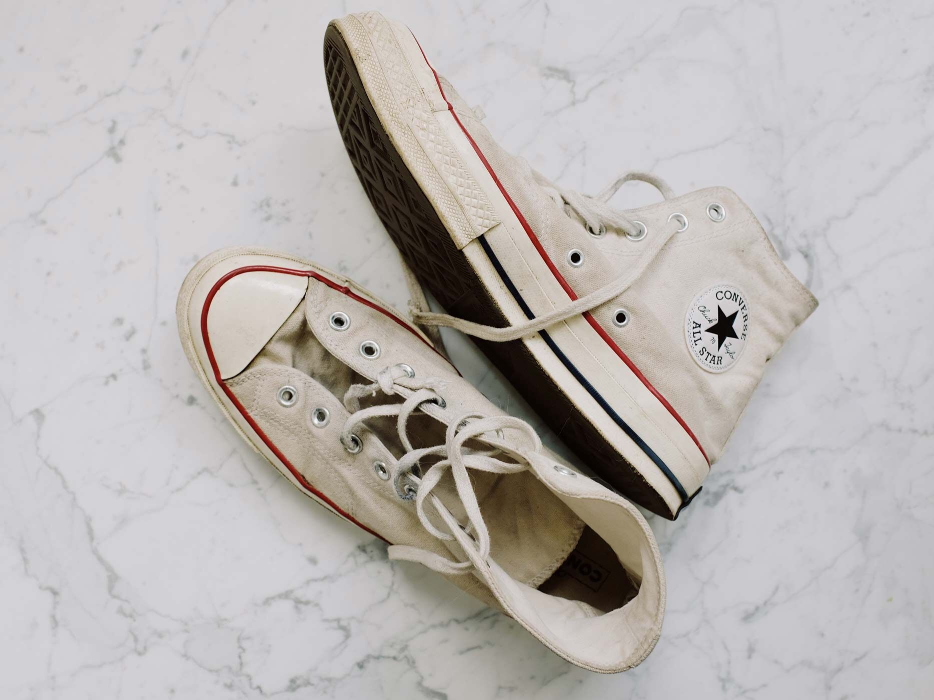 Beige Converse Schuhe von oben, einer liegend, einer stehend
