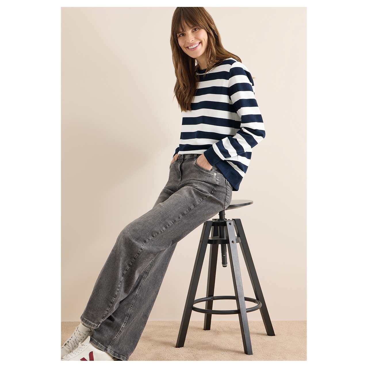 Damen Sweatshirt Striped von Cecil in Dunkelblau gestreift, Ganzkörperansicht am Model angelehnt an Hocker