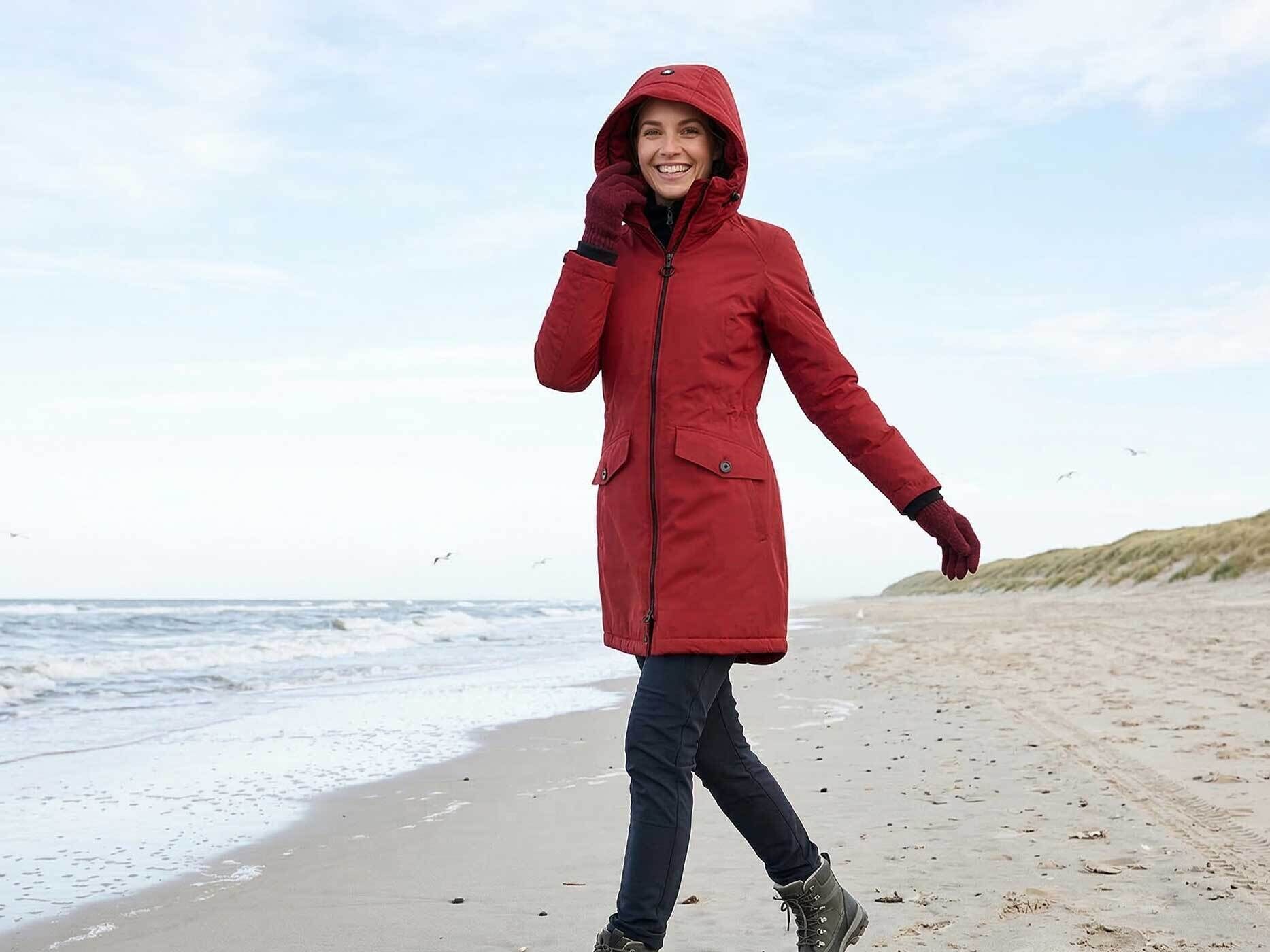 Frau trägt rote Wellensteyn Jacke am Strand