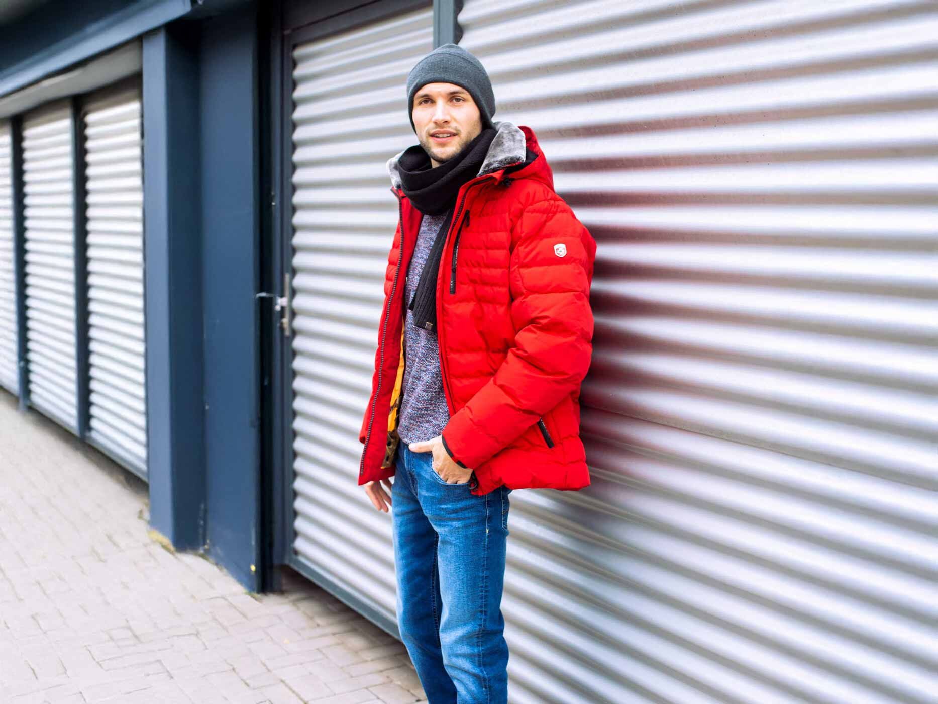 Ein Mann steht vor einer Garage, er trägt eine rote Wellensteyn Jacke.